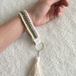 Learn how to crochet this wrist strap key chain with a tassel. Intermediate skill level required.